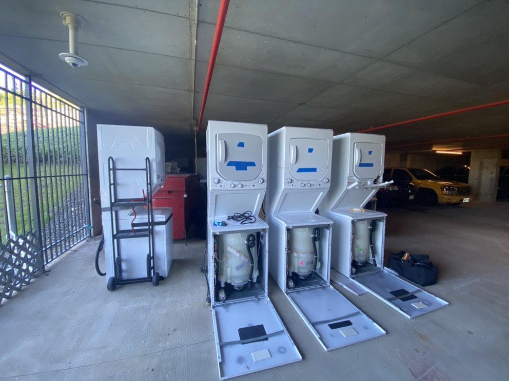 Multiple washer-dryer units opened up for repair by the TAKEO SERVICES team